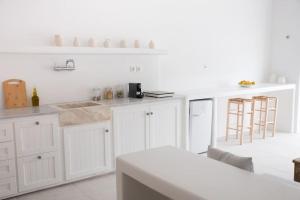 a white kitchen with white counters and white cabinets at Thavma Boathouse in Firopótamos
