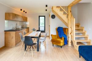 a kitchen and dining room with a table and chairs at Dom z balią in Mikołajki +17 photos