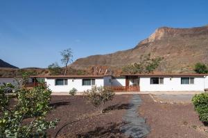 ein weißes Haus mit einem Berg im Hintergrund in der Unterkunft Country House Near Fataga y Maspalomas in Maspalomas