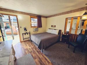 Cedar Wood Inn في ديدوود: غرفة نوم بسرير ومكتب وكرسي