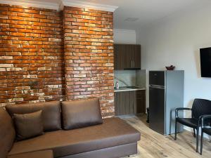 un soggiorno con divano e muro di mattoni di Hotel BRIFS a Shëngjin