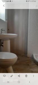 ein Badezimmer mit einem weißen WC und einem Waschbecken in der Unterkunft Apartment Doderovic in Kostrena