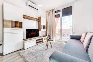 a living room with a couch and a tv at ARI GREEN Apartment near Atrium Mall in Arad