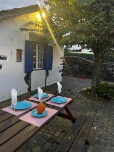 ein Picknicktisch mit Tellern und Obst darauf in der Unterkunft Vacas Felizes Villas in Ribeira Grande