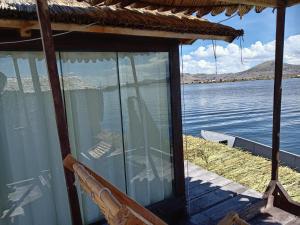 una pantalla en el porche de una casa con vistas al agua en Q'OTA TAYPY LODGE en Puno
