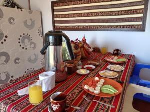uma mesa com uma cafeteira e pratos de comida em Q'OTA TAYPY LODGE em Puno