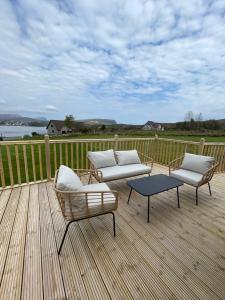 una terraza con 2 sillas, un sofá y una mesa en STORR (caravan skye holidays) en Portree