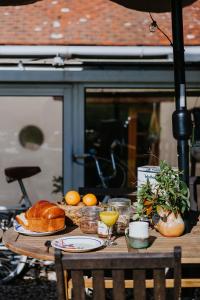 Una mesa con pan, naranjas y bebidas encima. en Maison La Pomaré, en Villeneuve-les-Genêts 5 fotos más
