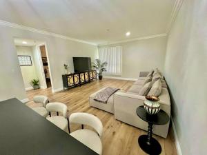 a living room with a couch and chairs and a television at Shared House Hollywood Hideaway Heart of Fame in Los Angeles