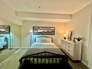 a bedroom with a bed and a dresser in it at Shared House Hollywood Hideaway Heart of Fame in Los Angeles