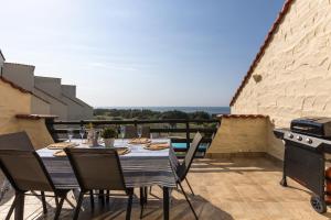 a dining table and chairs on a patio with a view at La Corsica 15, Uvongo in Margate