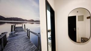 ein Spiegel an einer Wand neben einem Dock in der Unterkunft homy Lakeside Symphony in Bregenz am Bodensee in Bregenz