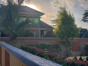 ein Haus mit einem Zaun und einem Garten mit Blumen in der Unterkunft Gipir & Labango Ventures in Entebbe