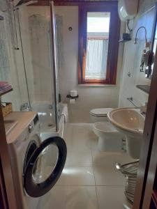 a bathroom with a toilet sink and a washing machine at Casa Lucrezia in Villa Gorizia