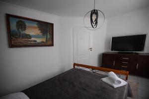 - une chambre avec un lit et une télévision à écran plat dans l'établissement Zakątek River, à Rajgród