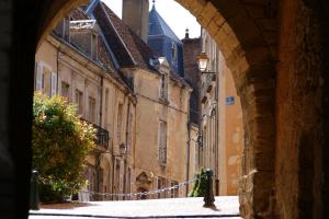 an alley with an archway in a city with buildings at Chalet bain nordique - Calm & relax - Wifi-Netflix-AppleTV-Canal in Bellême