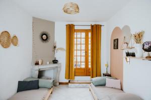 a living room with two couches and a fireplace at Maison La Pomaré in Villeneuve-les-Genêts +4 photos
