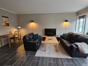 - un salon avec deux canapés en cuir et une table dans l'établissement Maritime apartment in Haugesund, à Haugesund