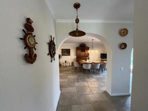 a kitchen and dining room with a clock on the wall at Czinege Vendégház - Nagy ház in Poroszló