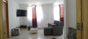 sala de estar con silla y TV. en apartamento de 2 habitaciones central en Cali, en Cali