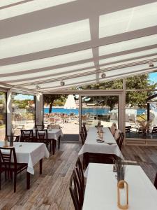 - un restaurant avec des tables et des chaises et une vue sur l'océan dans l'établissement Kanal-Haus "Das Gästehaus direkt am NOK", à Osterrönfeld