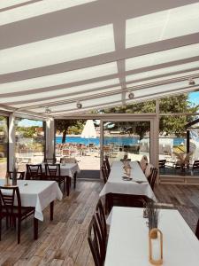 a restaurant with tables and chairs and a view of the ocean at Kanal-Haus "Das Gästehaus direkt am NOK" in Osterrönfeld