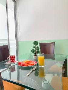 uma mesa de vidro com um prato de comida e um copo de sumo de laranja em Hotel Cabreromar By GEH Suites em Cartagena de Indias