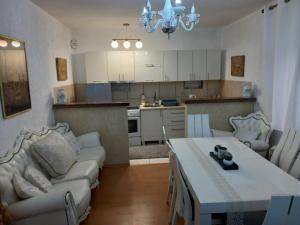 a living room with a couch and a table and a kitchen at Goran Apartmani in Igalo
