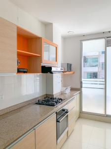 cocina con fogones horno superior junto a una ventana en Hotel Cabreromar By GEH Suites, en Cartagena de Indias