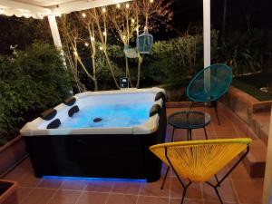 una bañera de hidromasaje en un patio con mesa y sillas en La Vecchia Taverna B&B, en Prignano Cilento