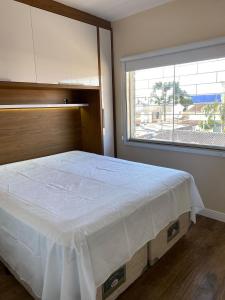 sypialnia z dużym łóżkiem i dużym oknem w obiekcie Ap completo proximo ao aeroporto w mieście São José dos Pinhais