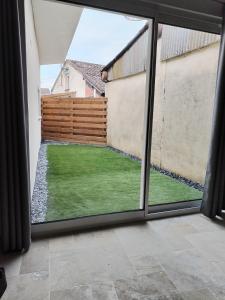 a view of a garden from a window at Charmante maison au calme in Verdun-sur-Garonne