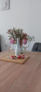 two glasses and a vase on a table with flowers at App MAJA Am Predigtstuhl in Sankt Englmar +24 photos