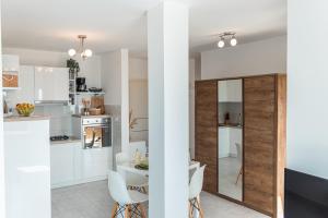a kitchen with white cabinets and a table and chairs at Carpe Diem**** in Lun +17 photos