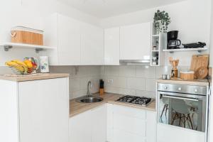 a white kitchen with a sink and a stove at Carpe Diem**** in Lun