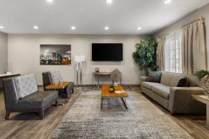 a living room with a couch and a tv at The Mulberry Hotel in Westlake