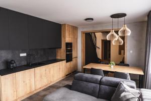 uma cozinha e sala de estar com uma mesa e um sofá em Luxusní Apartmán Domovjanka - SKALKA FAMILY em Bílá
