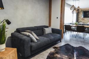 uma sala de estar com um sofá e uma sala de jantar em Luxusní Apartmán Domovjanka - SKALKA FAMILY em Bílá