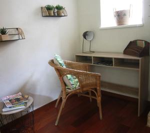 Zimmer mit einem Stuhl, einem Tisch und einem Regal in der Unterkunft Appartement le Clarté in Périgueux