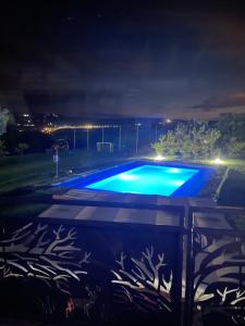 una piscina por la noche con luces azules en Wineyards Salin, en Turda