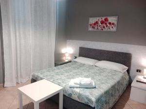 - une chambre avec un lit et une table blanche dans l'établissement Odori di zagara, à Caltanissetta