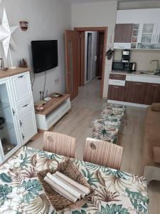 uma sala de estar com duas cadeiras e um sofá e uma cozinha em Megi Luxury Apartments em Pomorie