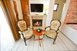 a living room with two chairs and a table and a fireplace at Agva Piazza Hotel in Agva