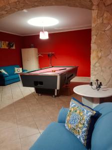 a living room with a pool table and red walls at Odori di zagara in Caltanissetta
