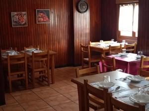 Pension Urola في زوماراغا: غرفة طعام مع طاولات وكراسي وساعة