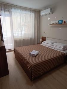 a hotel room with two beds and a window at Megi Luxury Apartments in Pomorie