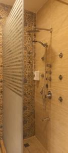 La salle de bains est pourvue d'une douche avec une porte en verre. dans l'établissement Villa amoun, à Sidi Krir