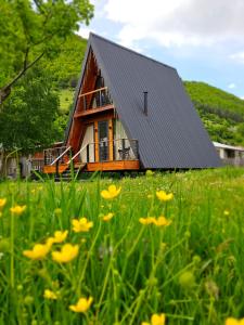 una casa con tetto nero in un campo di fiori di B&B Cottage in Mestia a Mestia