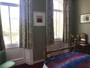 a bedroom with a bed and two windows at Tay View in Perth