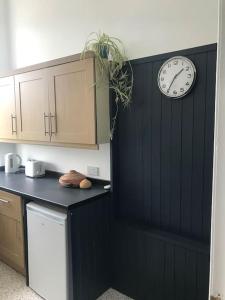 a kitchen with a clock on the wall and a counter at Tay View in Perth